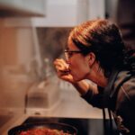 woman eating on cooking pan